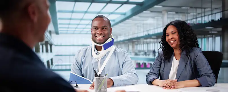 Injured couple meeting with a personal injury lawyer after a car accident