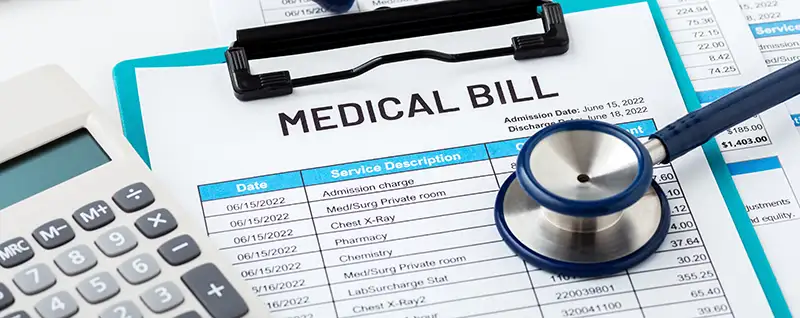 Medical bill on a clip board with a stethoscope and calculator