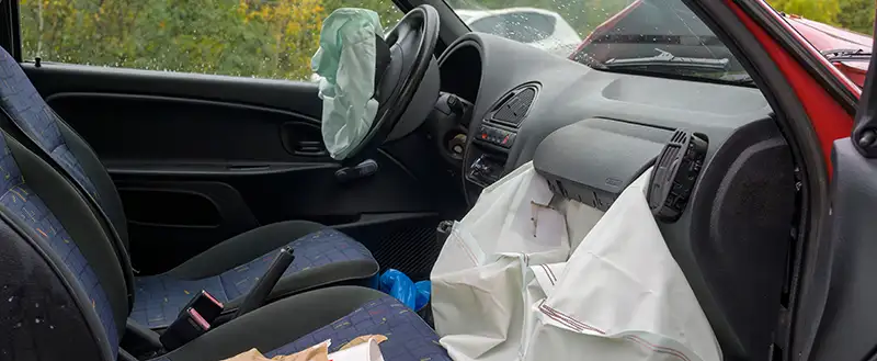 interior of a car with both the driver and passenger airbags deployed