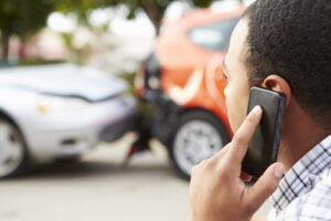 Man making phone call after car accident with an uninsured driver