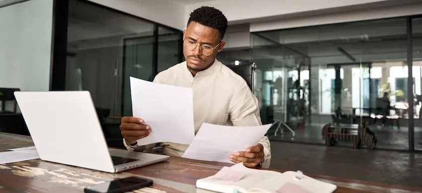 Early settlement risks are being reviewed by an Atlanta GA accident victim comparing insurance documents and claim offers at the Hodgins & Kiber law office.