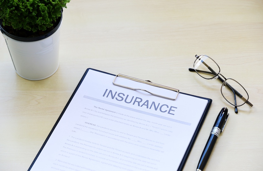 The first settlement offer from an insurance company is displayed on a clipboard for an Atlanta GA car accident claim review with a black pen and glasses beside it.