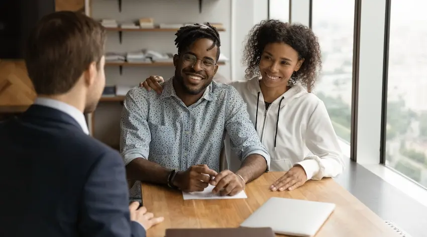 A young couple is meeting with an attorney to discuss a car accident claim settlement and compensation options in the Metro Atlanta area at Hodgins & Kiber LLC.