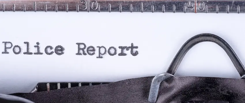 A vintage typewriter with a sheet of paper loaded and the words "Police Report" are typed across the page representing the official documentation used to record the details of an accident or crime scene investigation in Atlanta.