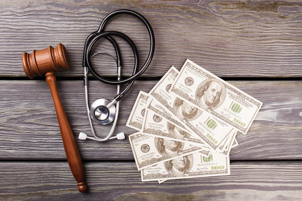 Medical bills and gavel representing hospital lawsuit threat over unpaid car accident medical debt in Atlanta