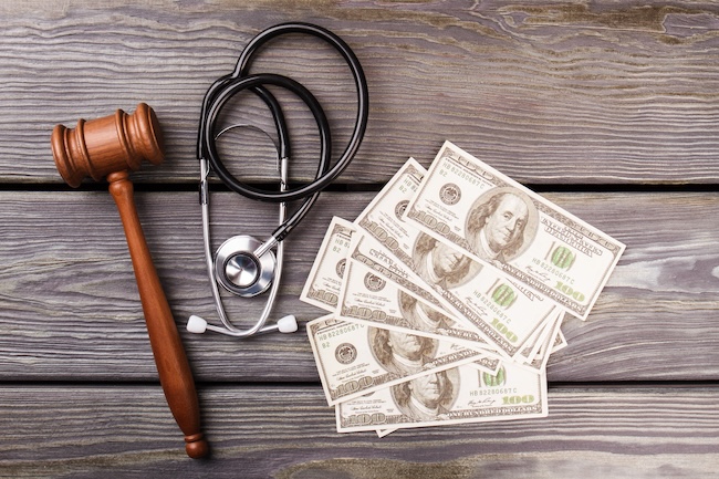 Medical bills and gavel representing hospital lawsuit threat over unpaid car accident medical debt in Atlanta