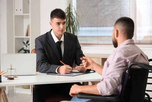 A man in a wheelchair meets a catastrophic injury lawyer.