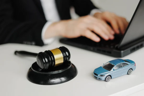 Atlanta car accident lawyer at desk with toy car and judge gavel