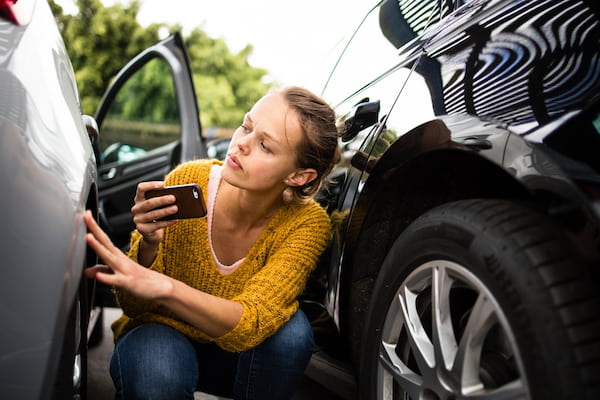 A woman takes photos after a car accident in Atlanta.